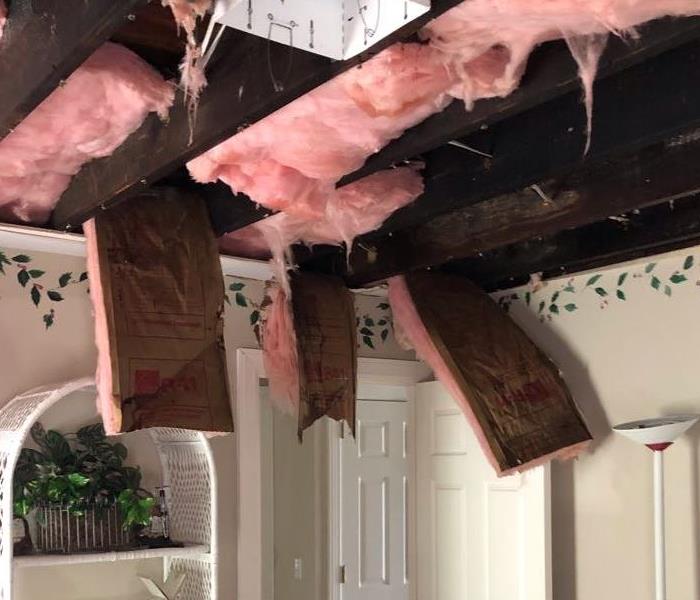 Insulation hanging from the ceiling after a water loss